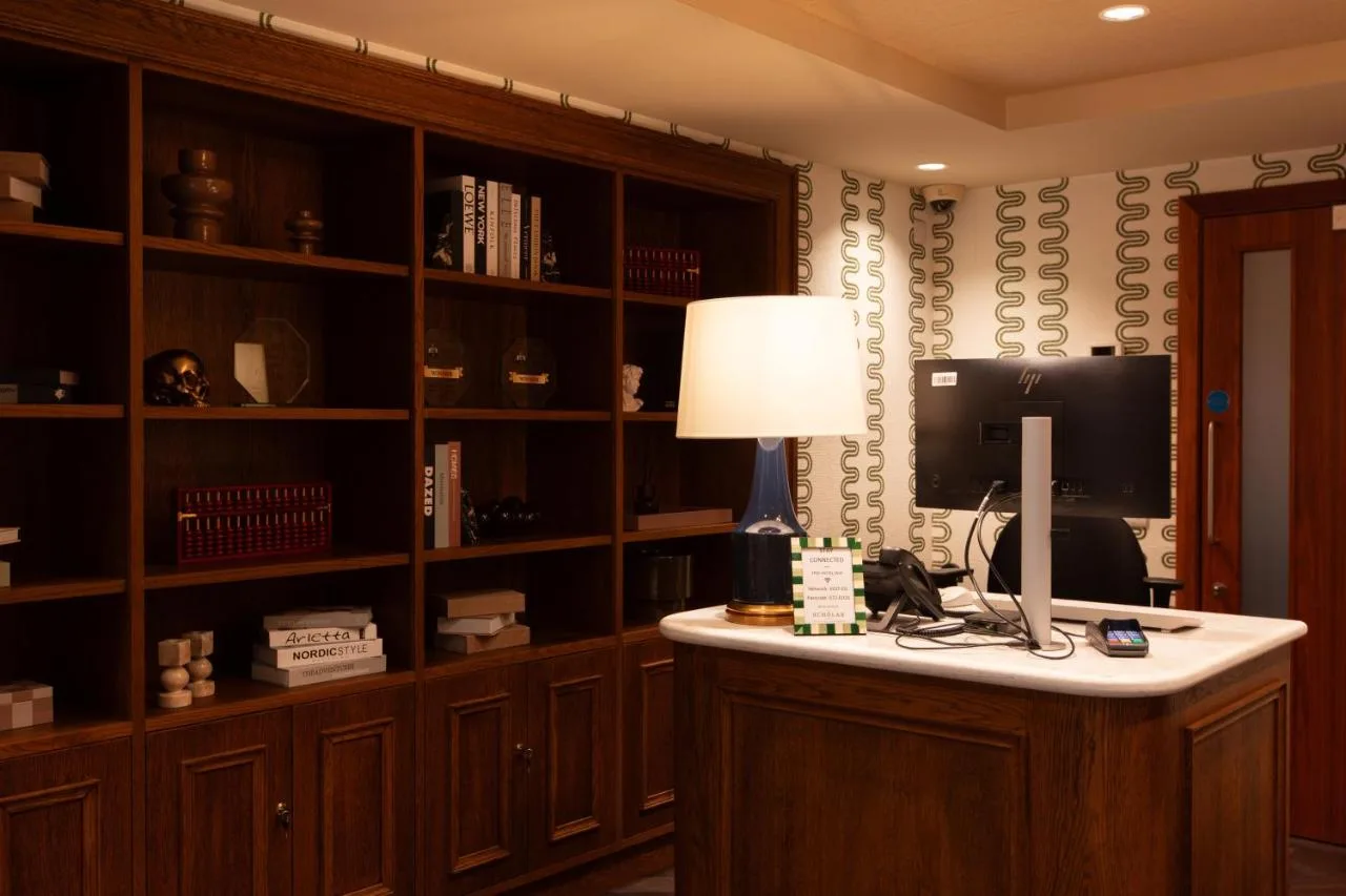 a room with a desk with a computer and a book shelf at The Scholar in Edinburgh
