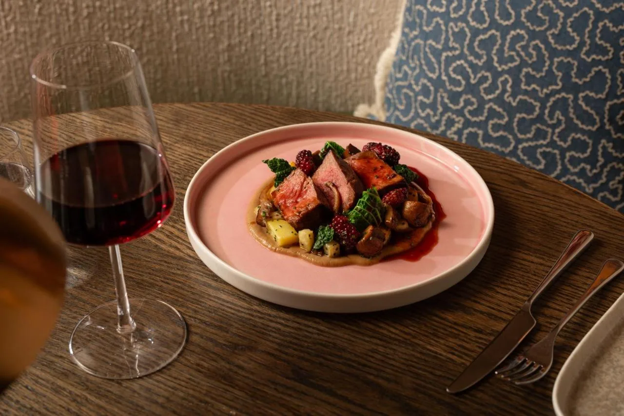 a plate of food on a table with a glass of wine at The Scholar in Edinburgh